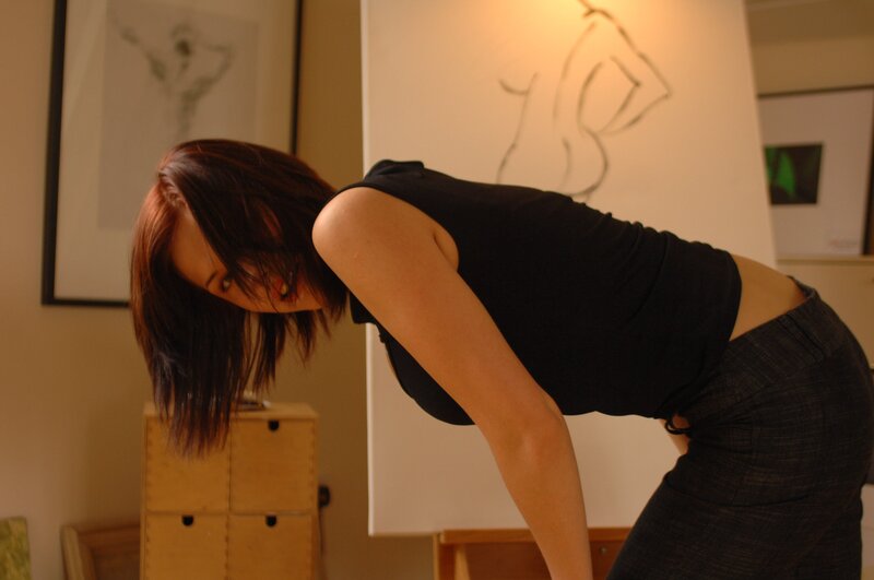 woman bending forward in art studio