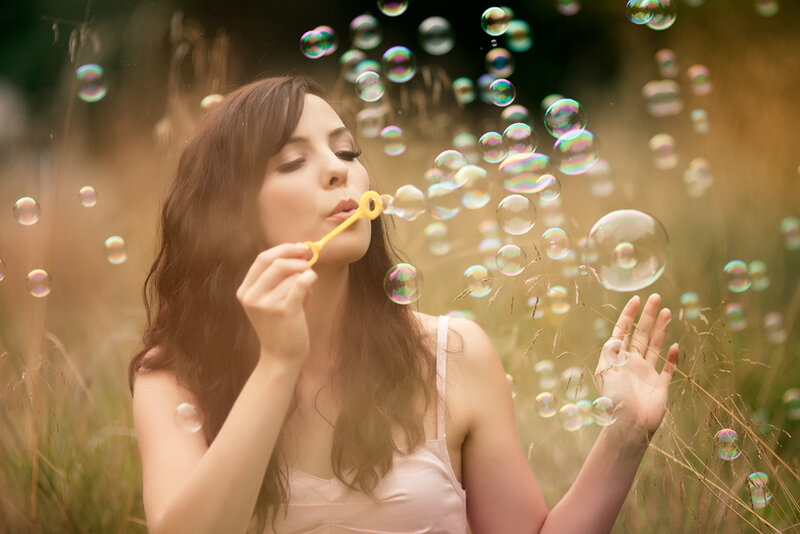 Woman Blowing Bubbles — Brown, Serene
