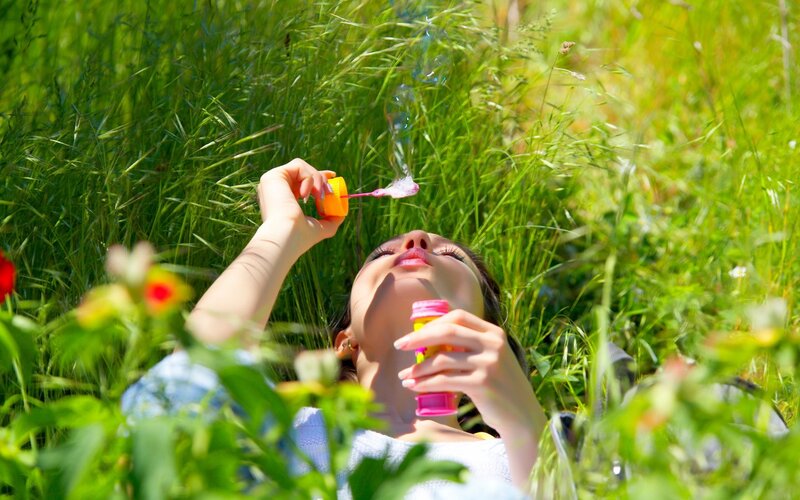 Woman Blowing Bubbles — Green, Serene, Afternoon