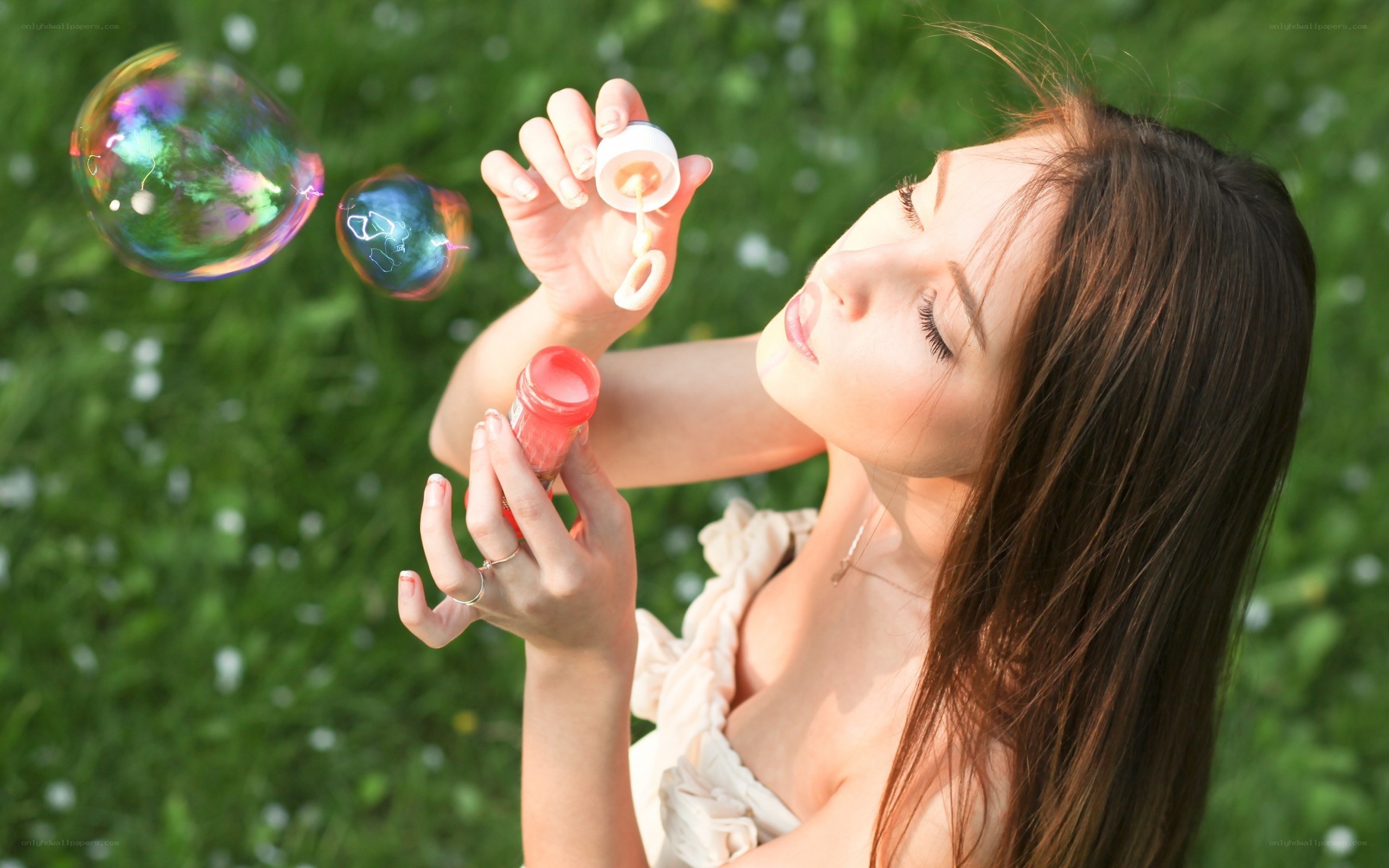 woman blowing bubbles in a field
