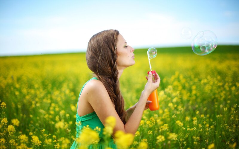 woman blowing bubbles in a field