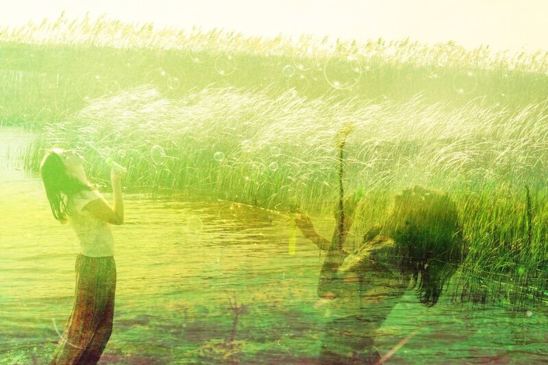 Woman blowing bubbles in a marsh
