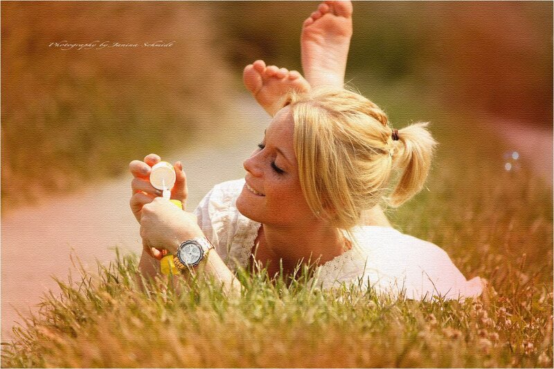 woman blowing bubbles in field