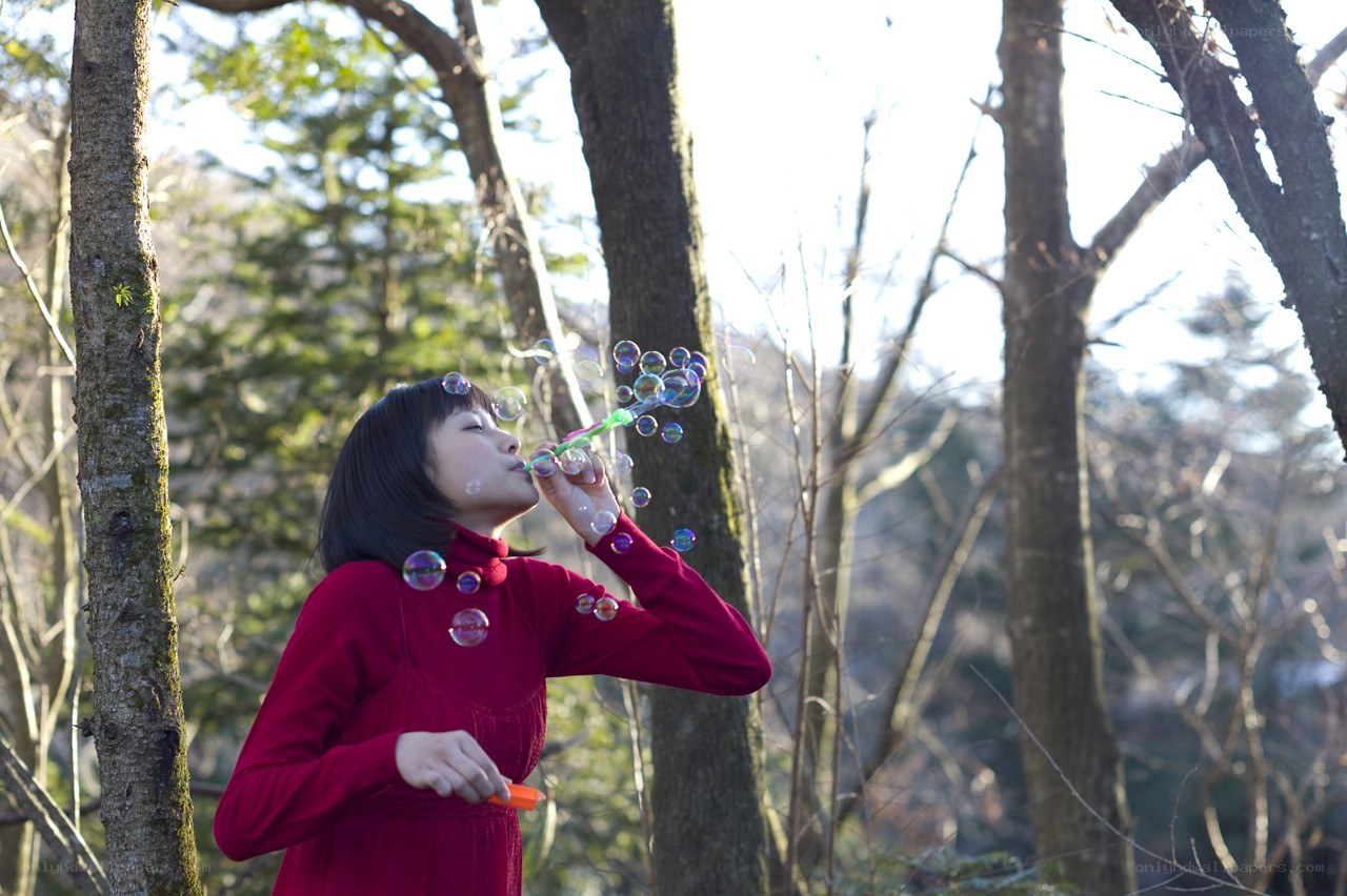 woman blowing bubbles in forest