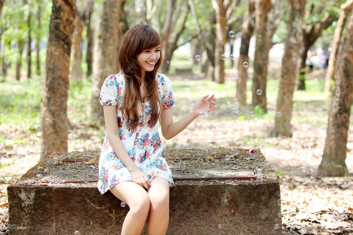 Woman blowing bubbles in park