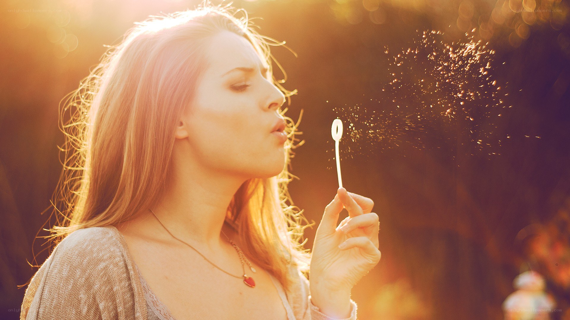 woman blowing bubbles in sunlight