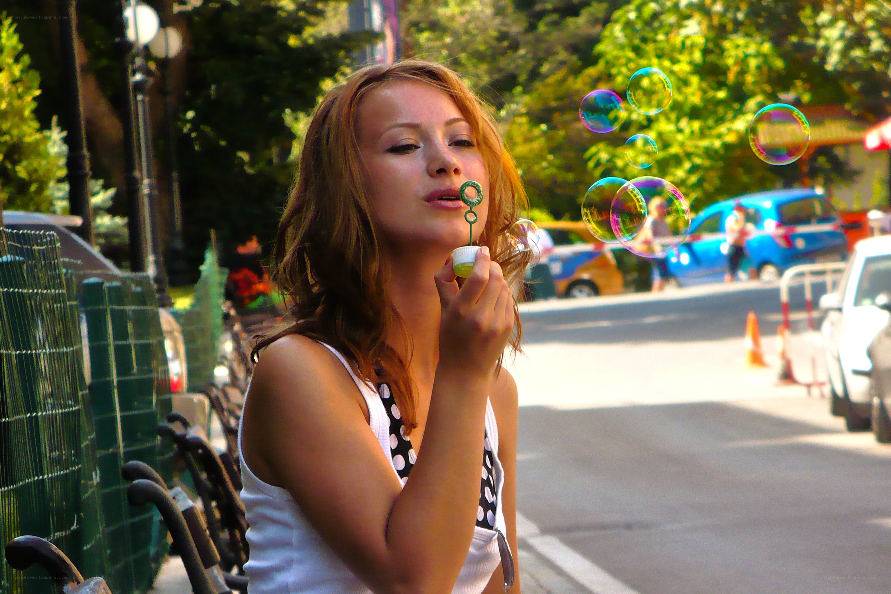 Woman blowing bubbles on street