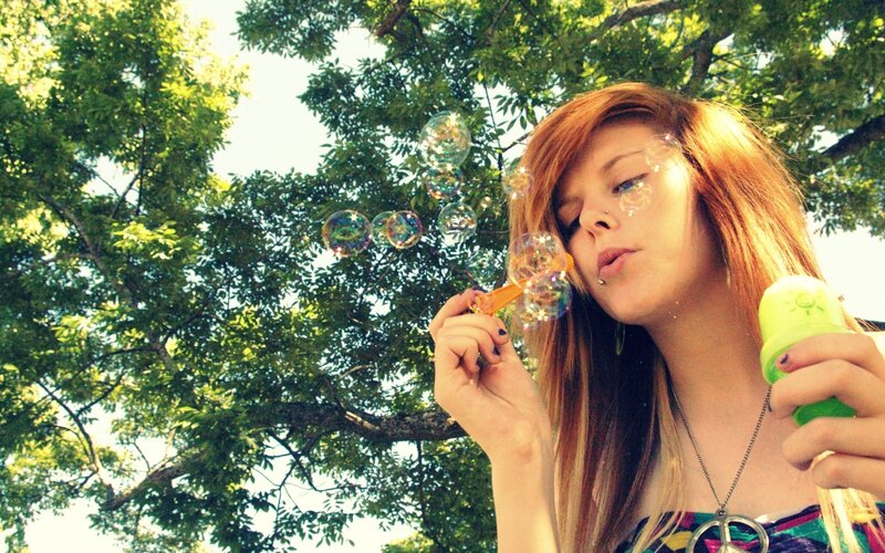 woman blowing bubbles outdoors