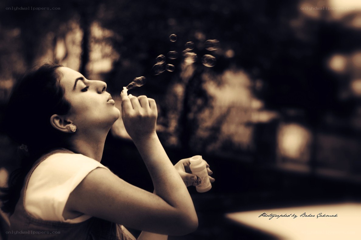 woman blowing bubbles outdoors