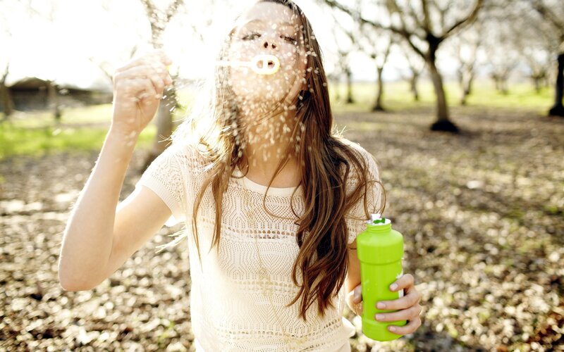 woman blowing bubbles outdoors