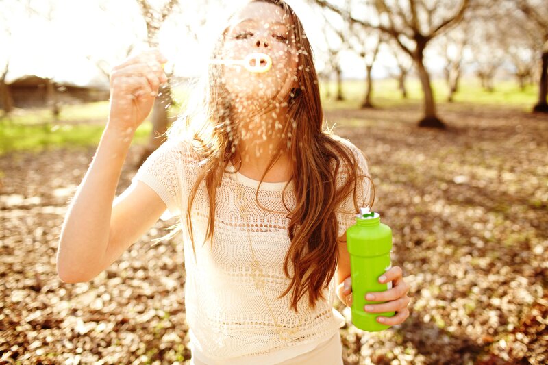 woman blowing bubbles outdoors