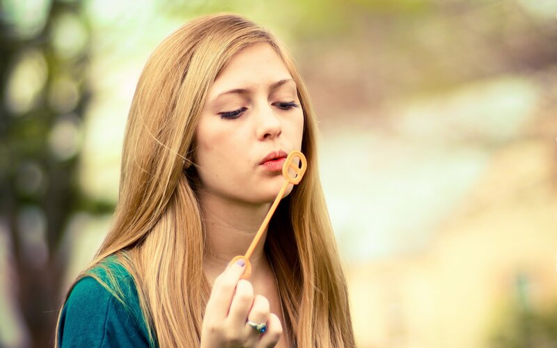 woman blowing bubbles outdoors