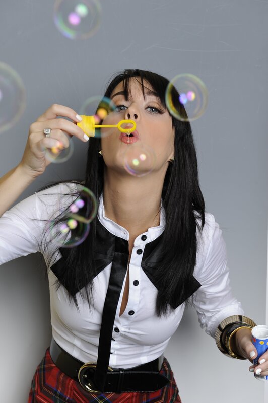 Woman Blowing Bubbles — White, Playful, Photograph, Plaid Skirt