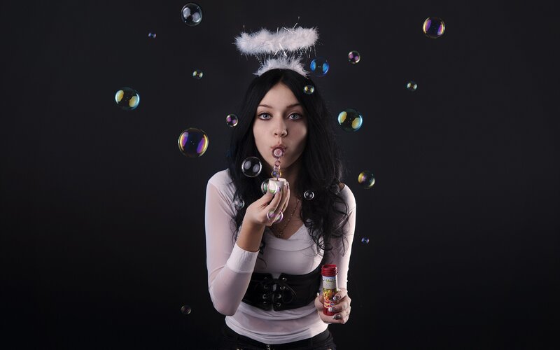 woman blowing bubbles with angel wings
