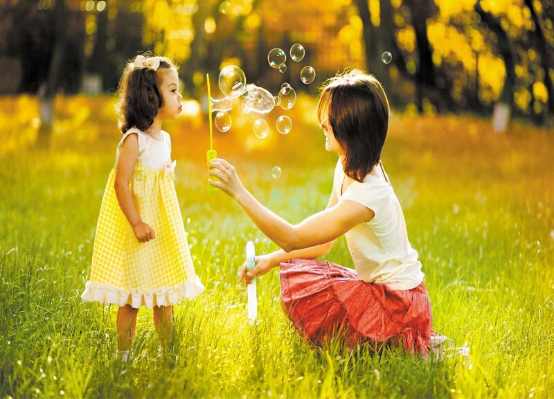 Woman Blowing Bubbles with Child