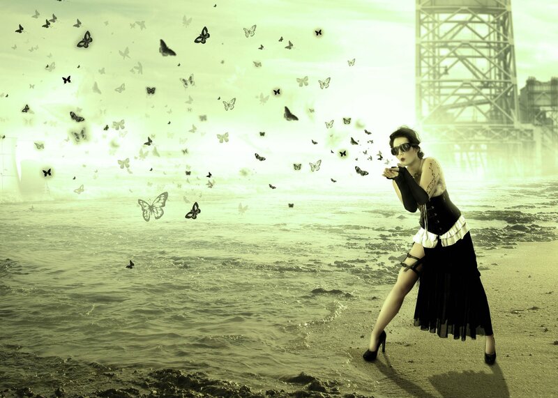 woman blowing butterflies on beach
