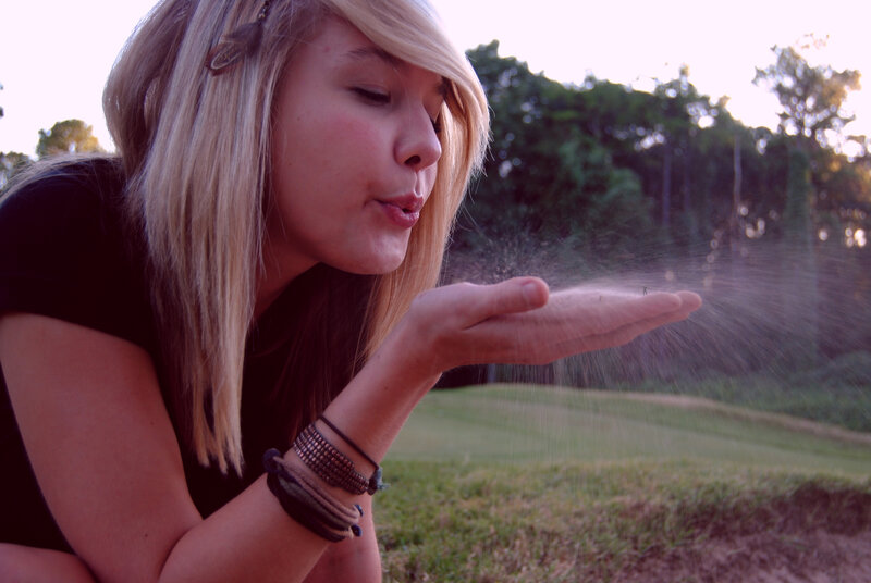 woman blowing dust in park