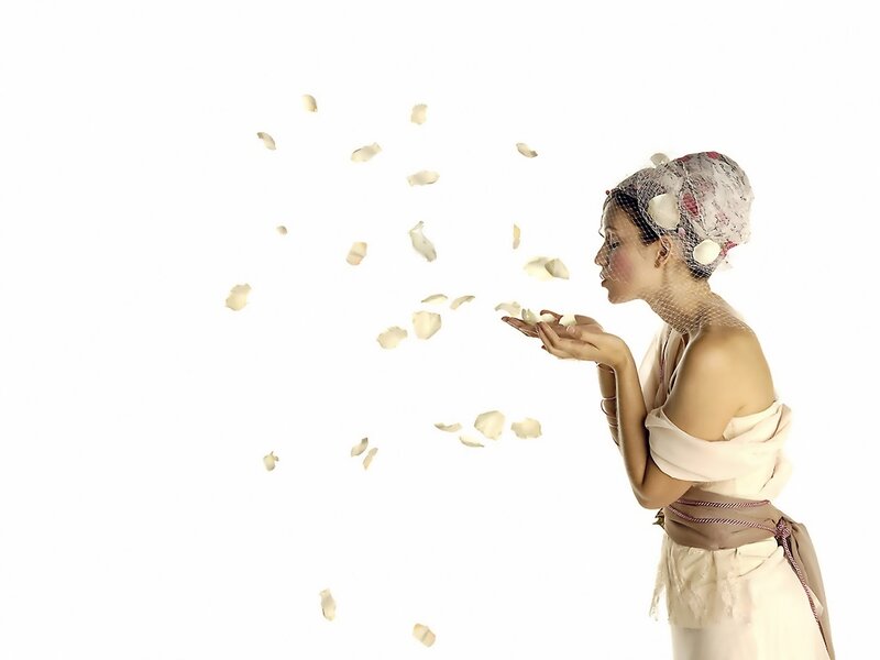 woman blowing flower petals