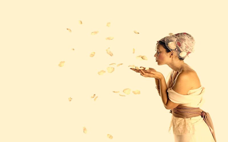 woman blowing flower petals