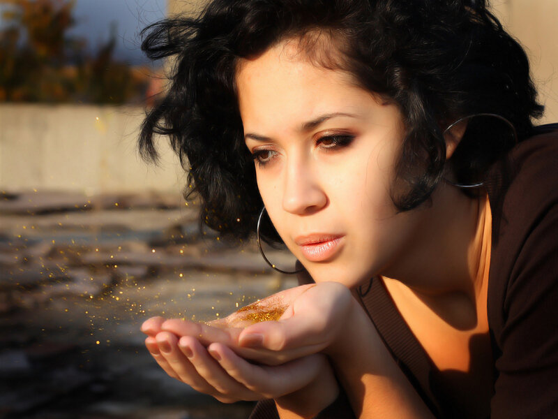 woman blowing glitter from her hand