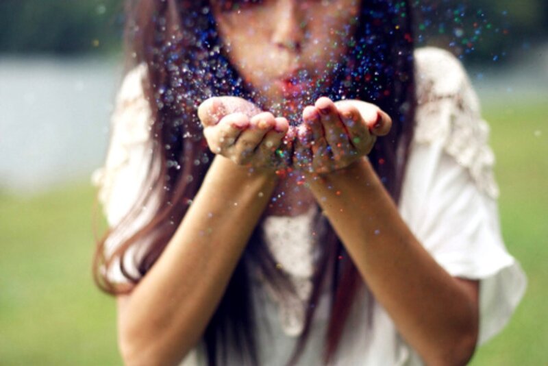 woman blowing glitter outdoors