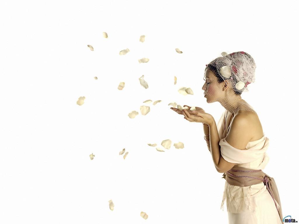woman blowing rose petals