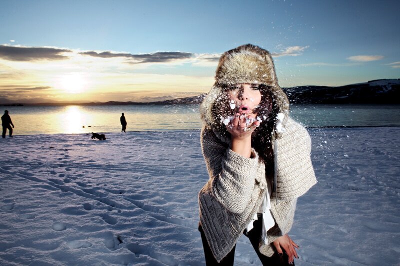 Woman blowing snow in winter