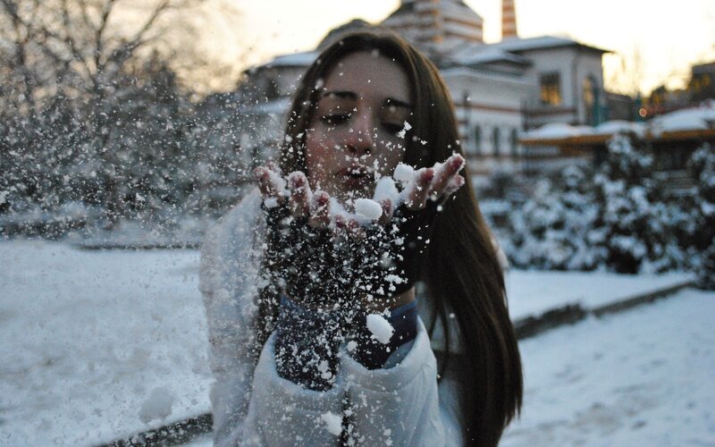 woman blowing snow outdoors