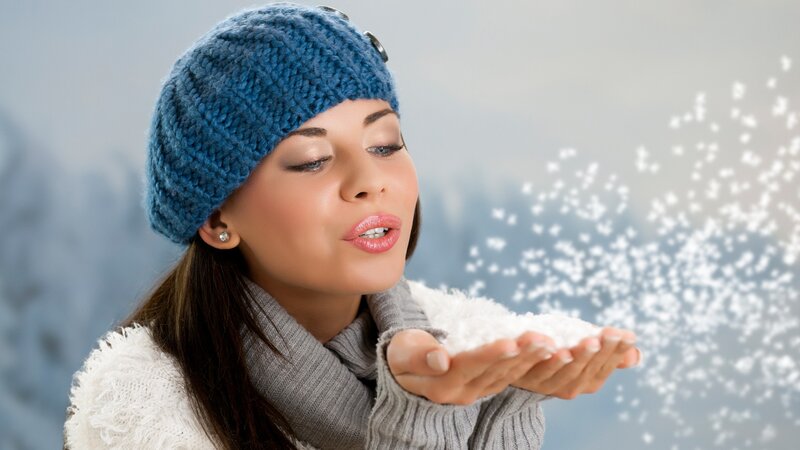woman blowing snowflakes