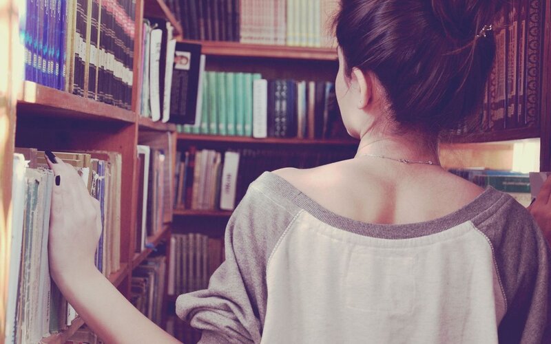 Woman browsing books in library