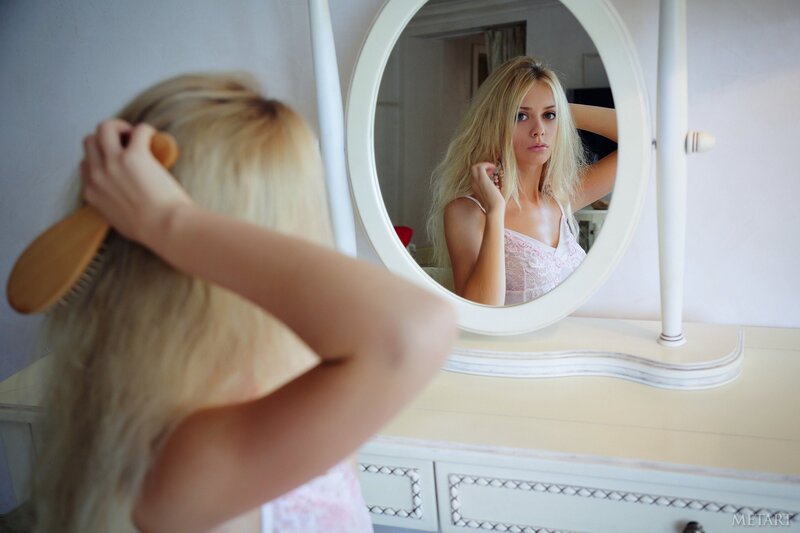 woman brushing hair in mirror
