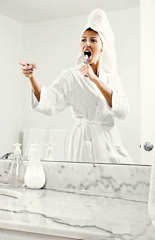 woman brushing teeth in bathroom