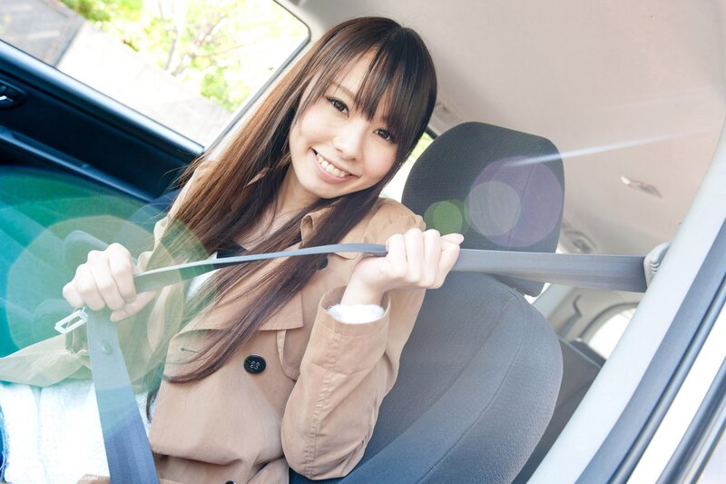 Woman buckling seatbelt in car