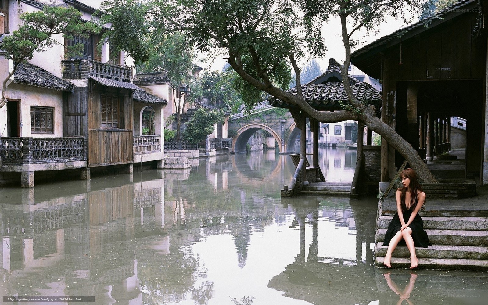 Woman by a canal in a traditional town