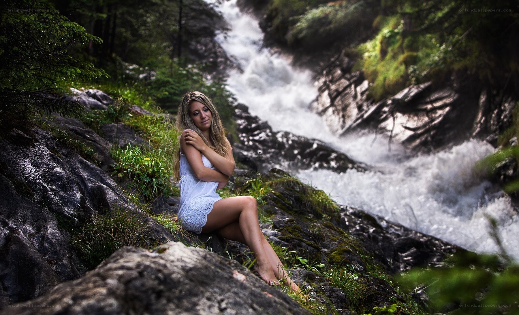 Woman by a forest waterfall