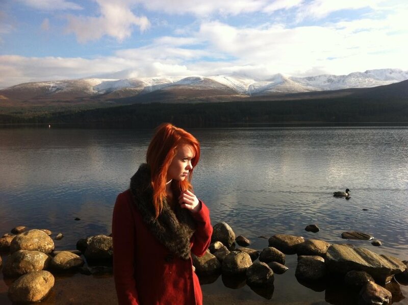 Woman by a lake with mountains