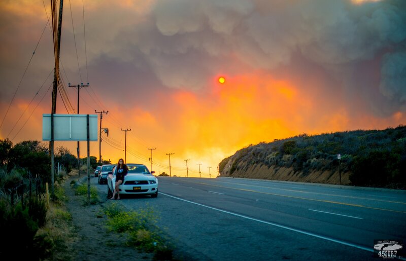 Woman by car during wildfire