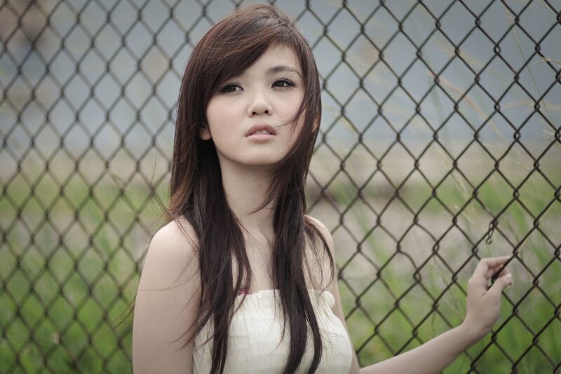 woman by chain-link fence