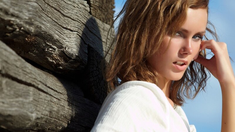 woman by driftwood on beach