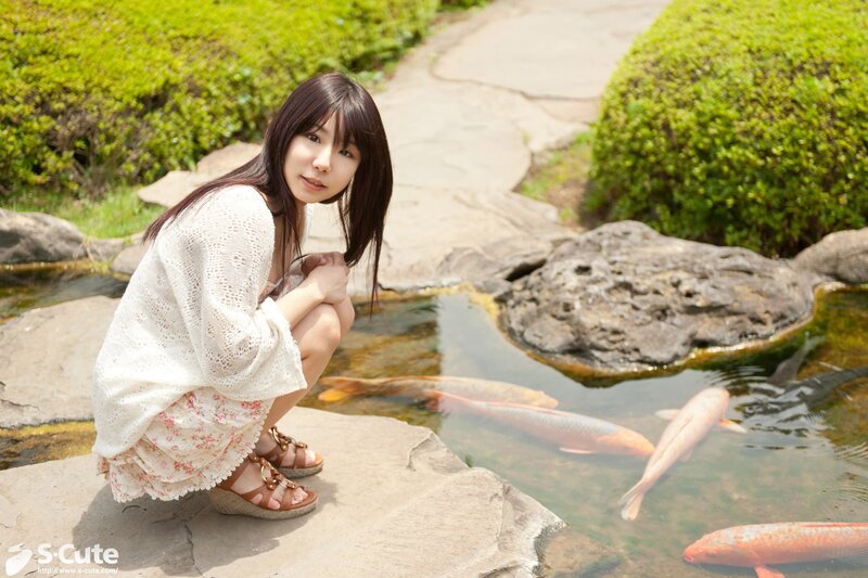 Woman by koi pond in garden