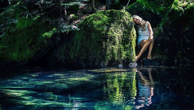 woman by mossy rock in forest