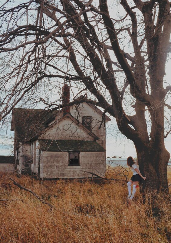 woman by old house and tree