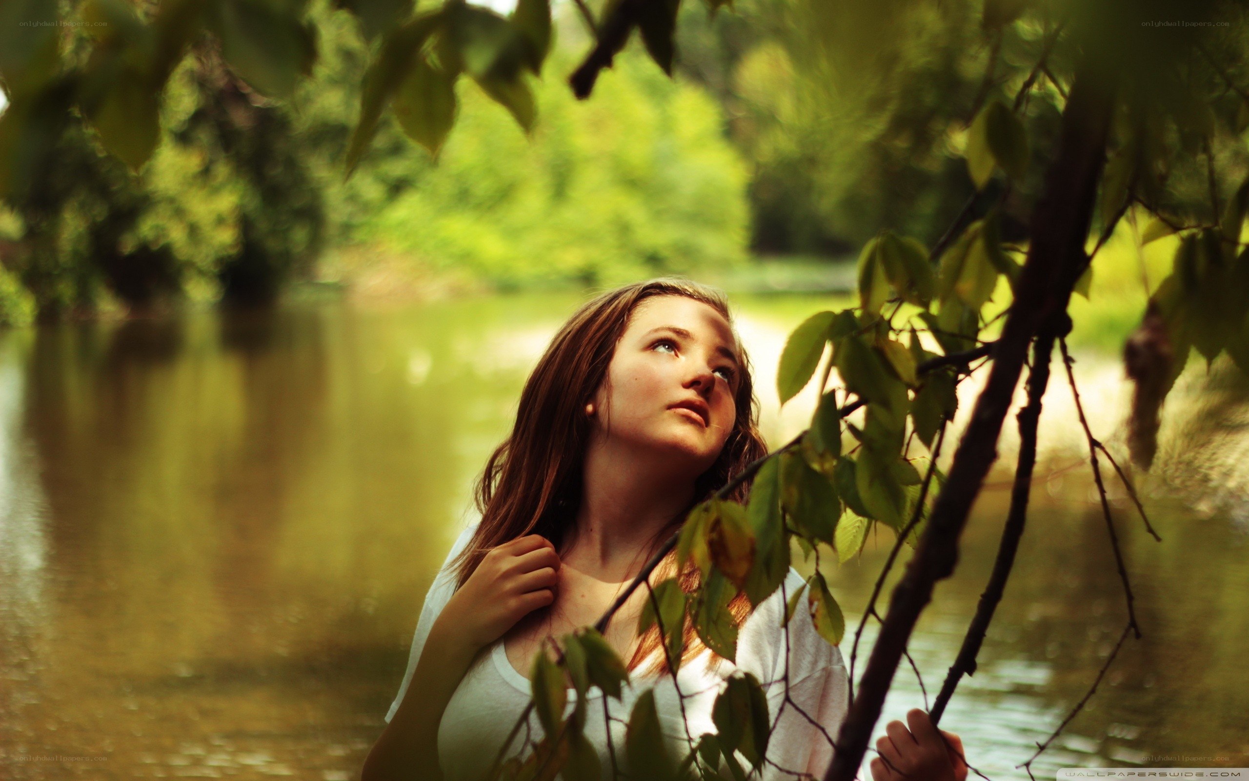 woman by the river under trees