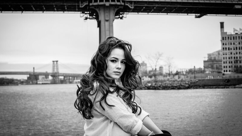 woman by the river with bridge