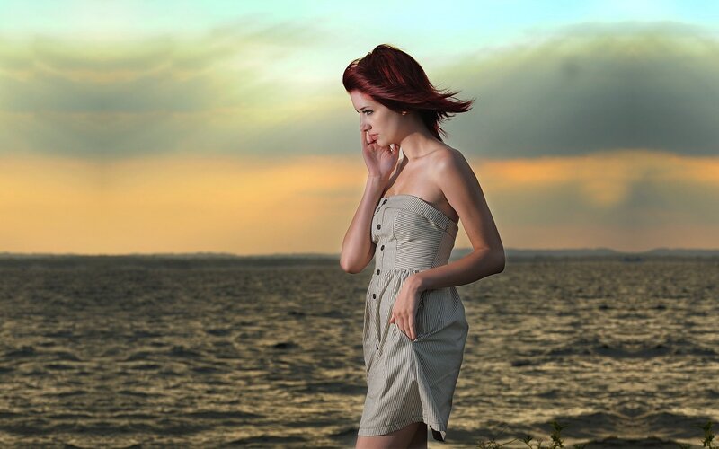 Woman by the sea at sunset