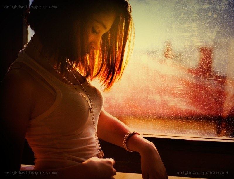 woman by the window at sunset