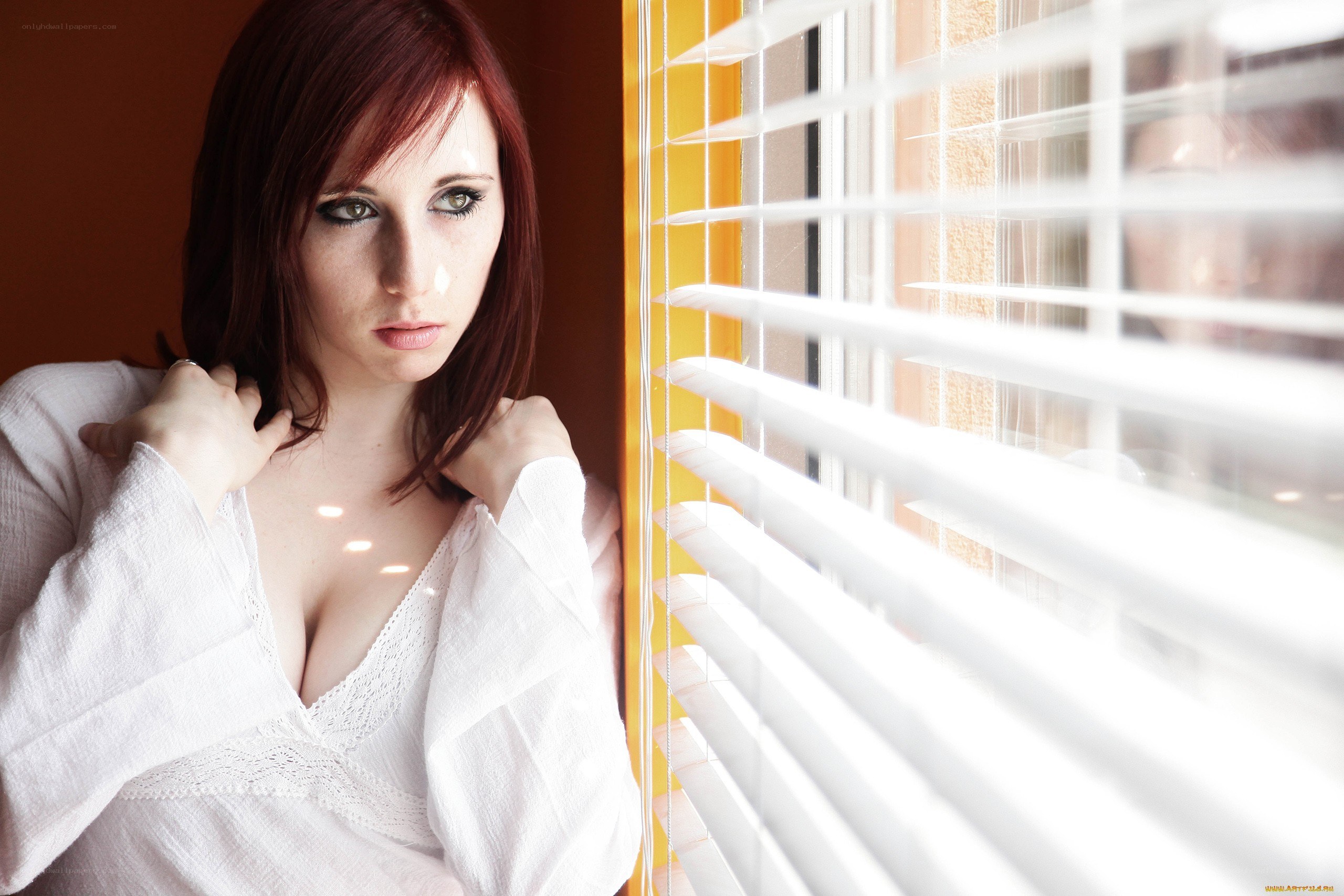 woman by window with blinds