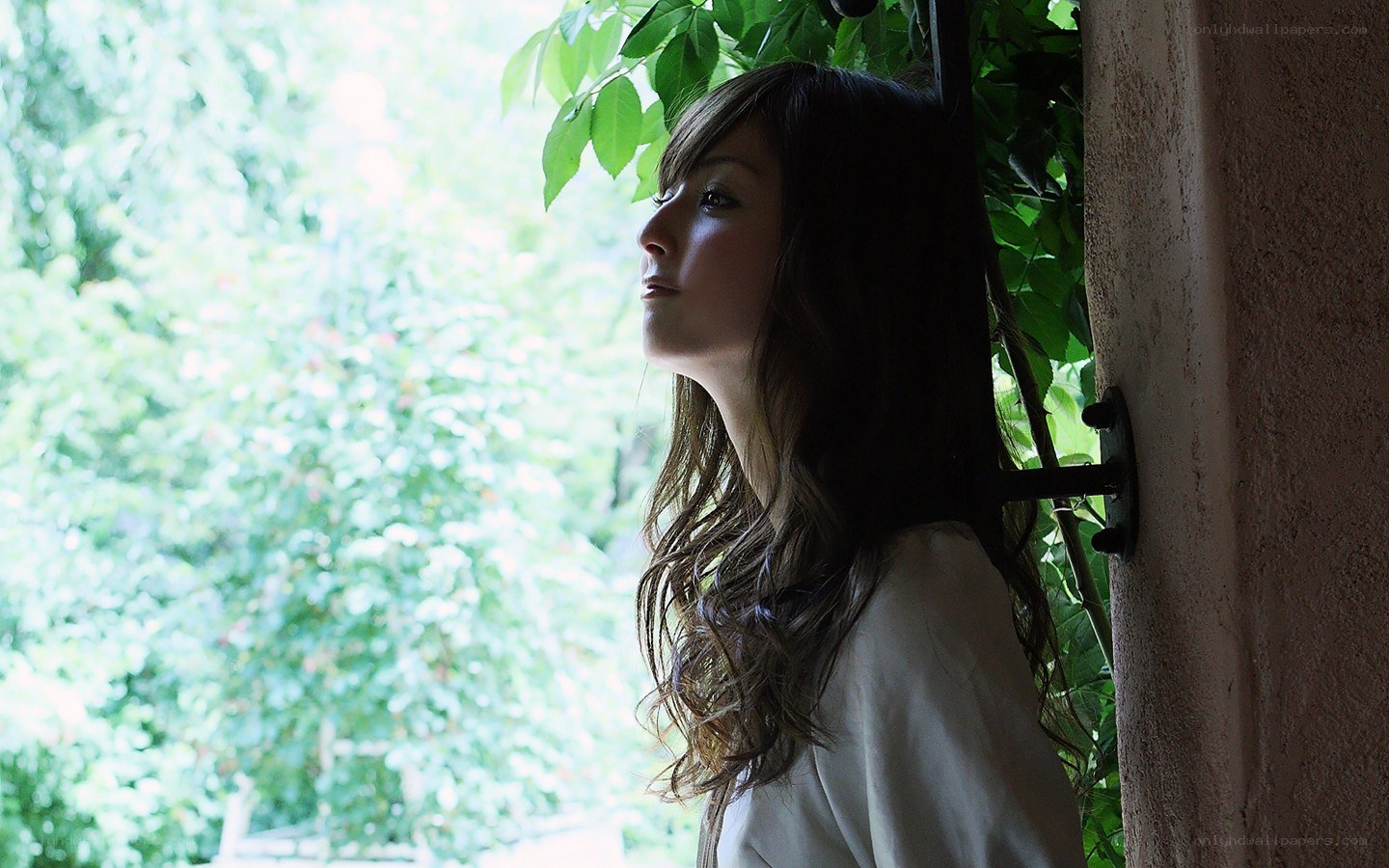 woman by window with greenery