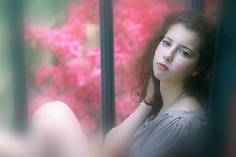 woman by window with pink flowers