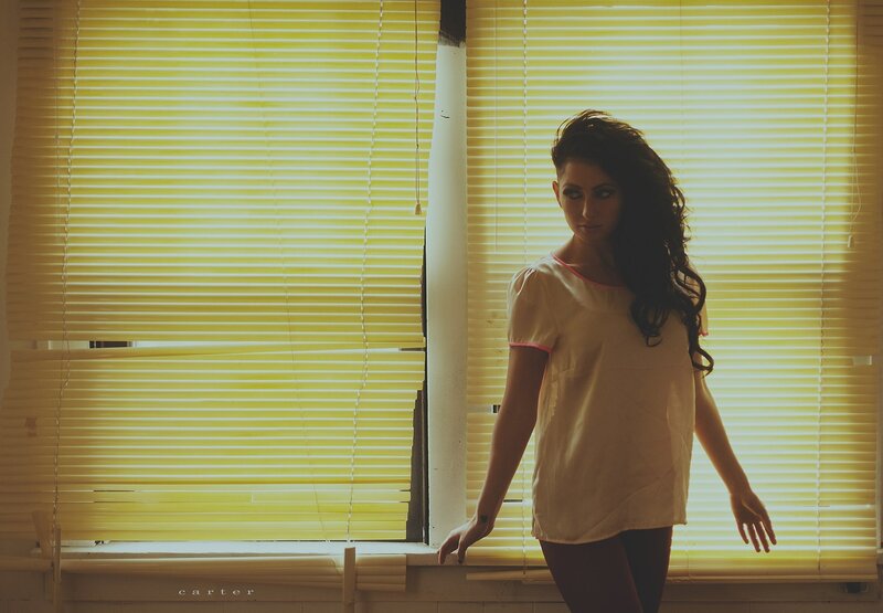 woman by yellow blinds